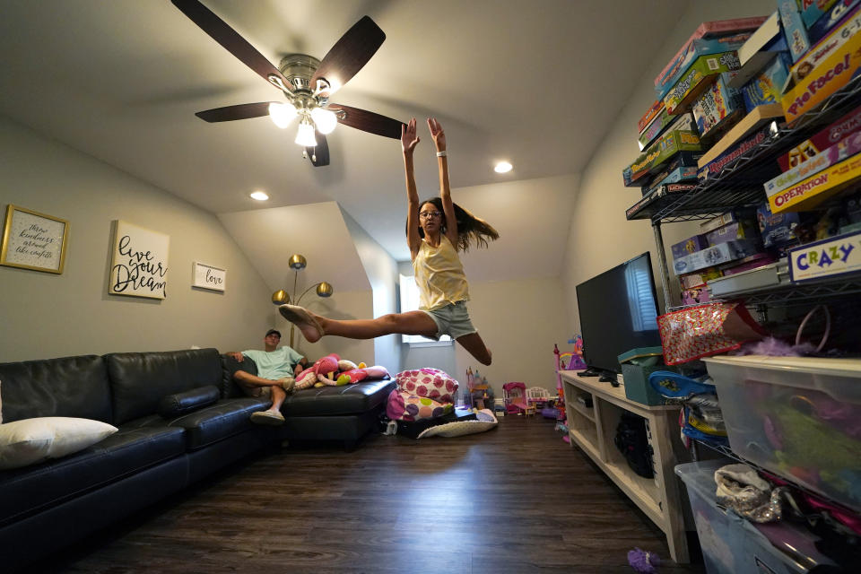 Cecilia Shaffette practices her dance routine in front of her father Rhett Shaffette at their home in Carriere, Miss., Wednesday, June 16, 2021. The 12-year-old is thriving, eight months after getting a portion of her father's liver. She received the transplant after nearly losing her life to internal bleeding. (AP Photo/Gerald Herbert)