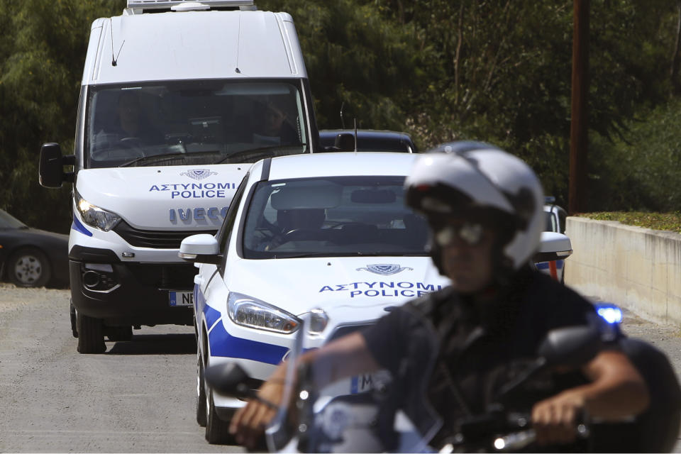 A motorcyclist police officer escorts and guards the police van carrying Army Captain Nicholas Metaxas from the court to the Cypriot central prison in capital Nicosia, Cyprus, Monday, June 24, 2019. A Cypriot army captain on Monday tearfully apologized to the families of seven foreign women and girls for the "unjust pain" he has caused them after pleading guilty to a dozen charges of premeditated murder and kidnapping. (AP Photo/Petros Karadjias)