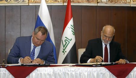 Iraqi Foreign Minister Ibrahim al-Jaafari (R) and Russia's Deputy Prime Minister Dmitry Rogozin (L) sign documents in Baghdad, Iraq February 11, 2016. REUTERS/Khalid al Mousily