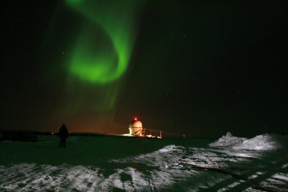 A photographer captures images of the northern lights Thursday, April 12, 2012, near an observatory outside Fairbanks, Alaska.