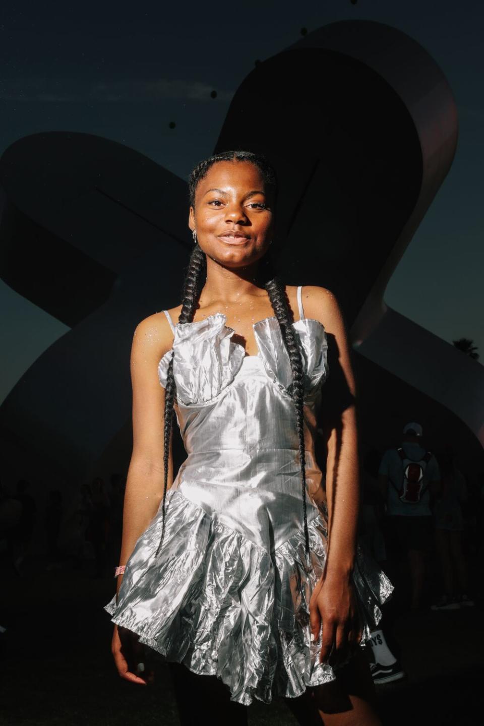 A woman poses in a silvery dress