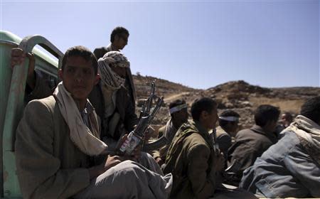 Followers of Yemen's Shi'ite Houthi group hold their weapons as they sit on a vehicle to patrol a road leading to the northwestern province of Saada January 23, 2013. REUTERS/Mohamed al-Sayaghi