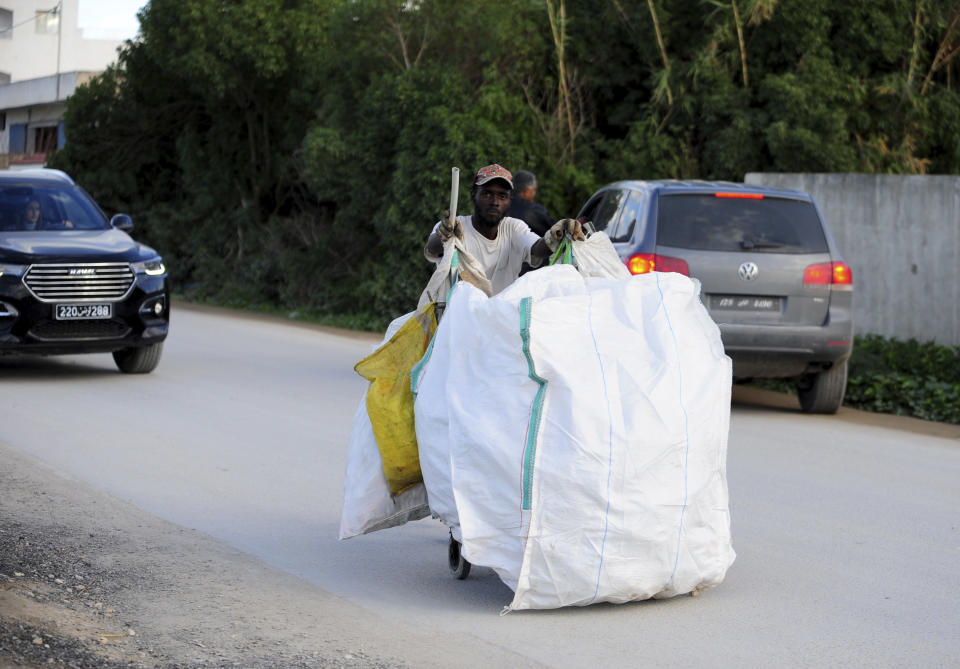 A plastic picker works in La Marsa, outside Tunis, Wednesday, Dec. 14, 2022. To outsiders, Tunisia’s legislative elections Saturday, Dec. 17, 2022 look questionable: Many opposition parties are boycotting. A new electoral law makes it harder for women to compete. Foreign media aren’t allowed to talk to candidates. But many voters believe that their country’s decade-old democratic revolution has failed, and welcome their increasingly autocratic president’s political reforms. (AP Photo/Hassene Dridi)