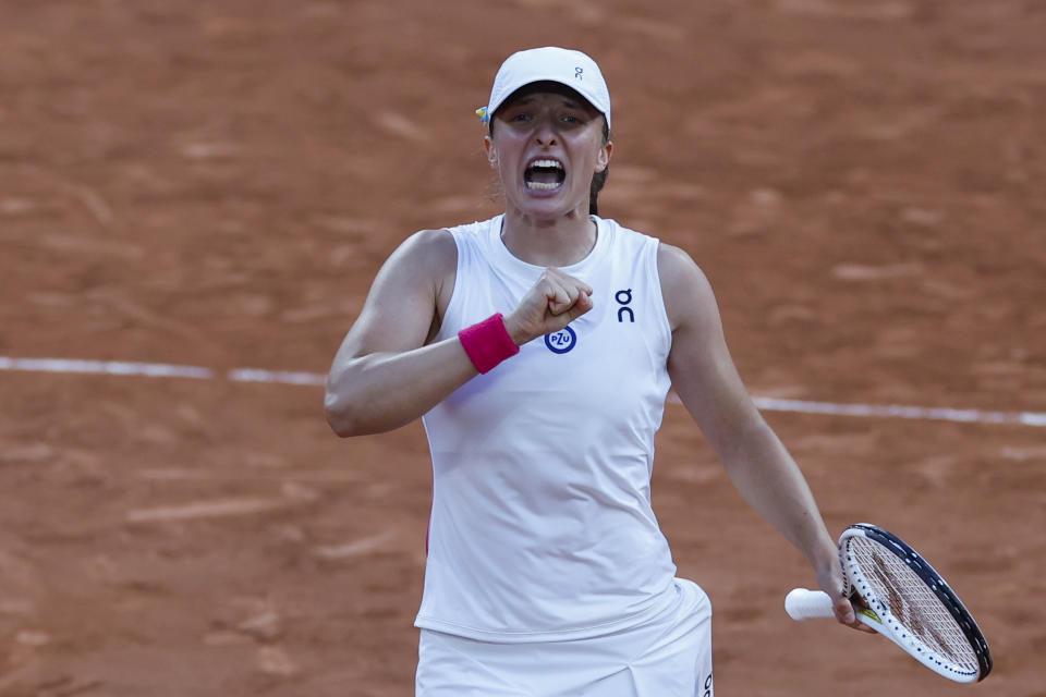 Poland's Iga Swiatek celebrates winning her semifinal match of the French Open tennis tournament of the French Open tennis tournament against Brazil's Beatriz Haddad Maia in two sets, 6-2, 7-6 (9-7),at the Roland Garros stadium in Paris, Thursday, June 8, 2023. (AP Photo/Jean-Francois Badias)