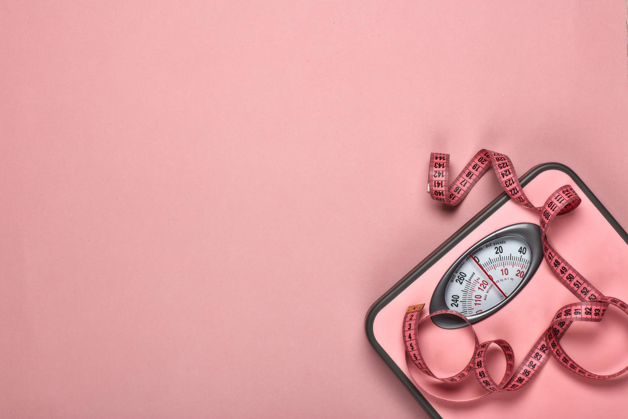 Female fitness still life. Scales and measuring tape on pink background. Mockup. Planning of diet and trainings. Top view with copy space. Healthy lifestyle concept. Slimming