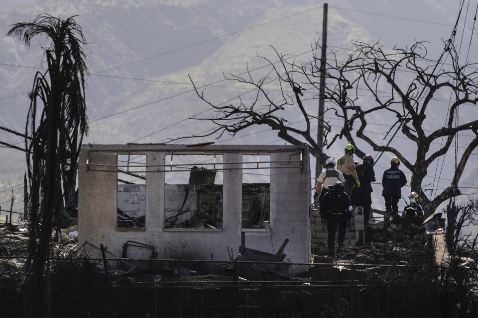 FILE - Search and rescue team members work in a residential area devastated by a wildfire in Lahaina, Hawaii, Aug. 18, 2023. Hawaii lawmakers on Wednesday, May 1, 2024, approved funds for more firefighting equipment and a state fire marshal after the deadliest U.S. wildfire in more than a century ripped through the historic Maui town of Lahaina and exposed shortcomings in the state's readiness for such flames. (AP Photo/Jae C. Hong, File)