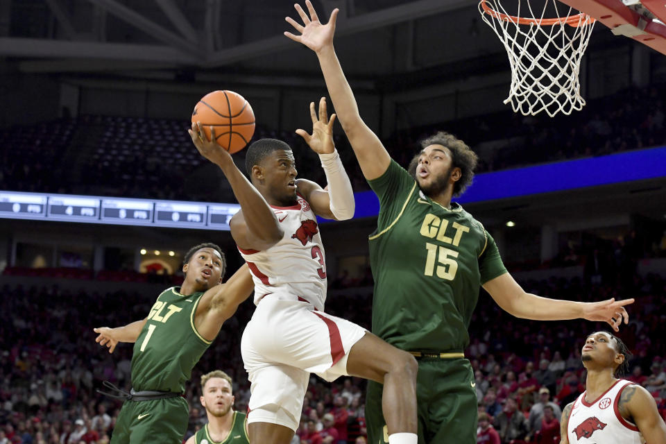 Arkansas forward Trey Wade (3) tries to shoot over Charlotte defenders Jahmir Young (1) and Aly Khalifa (15) during the first half of an NCAA college basketball game Tuesday, Dec. 7, 2021, in Fayetteville, Ark. (AP Photo/Michael Woods)