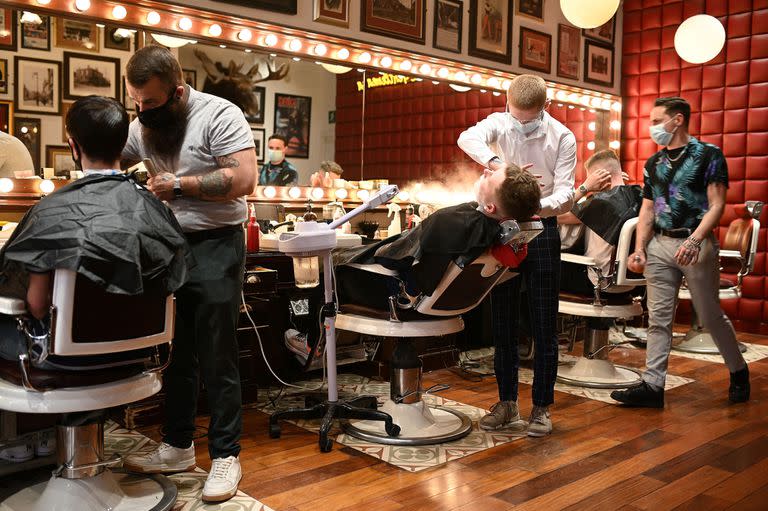 Varios jóvenes se cortan el cabello en "Barber Barber Barbers" en Liverpool, Inglaterra