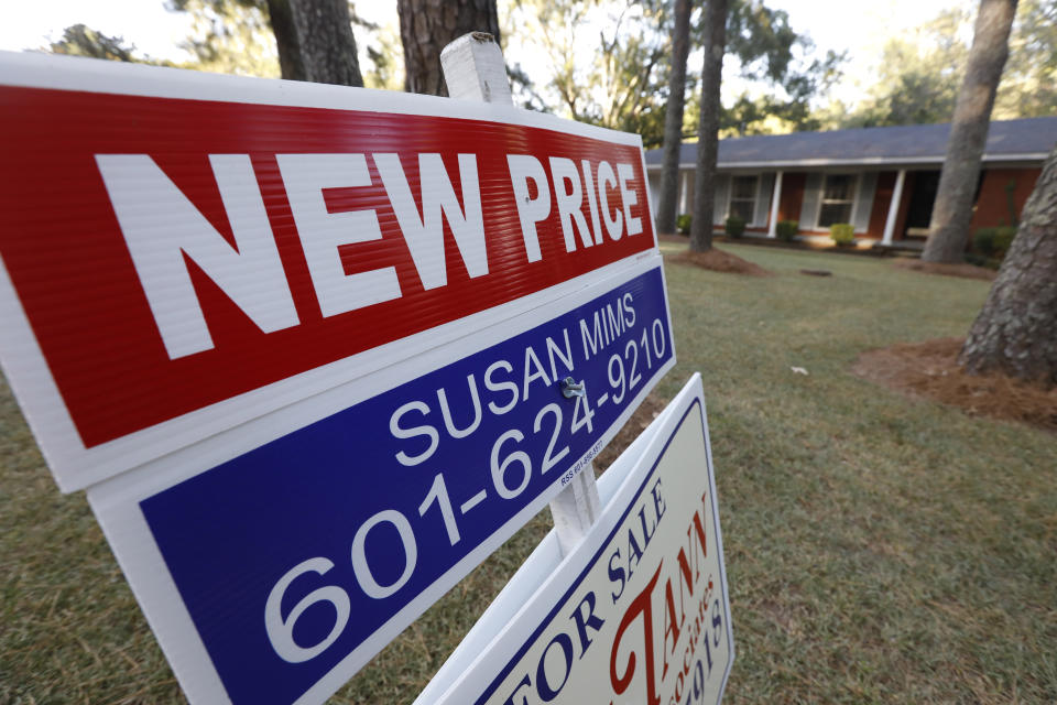 FILE - In this Sept. 25, 2019, file photo a sign indicating a new selling price for a house sits atop a realtor's sign in Jackson, Miss. On Tuesday, Nov. 26, the Standard & Poor's/Case-Shiller 20-city home price index for September is released. (AP Photo/Rogelio V. Solis, File)