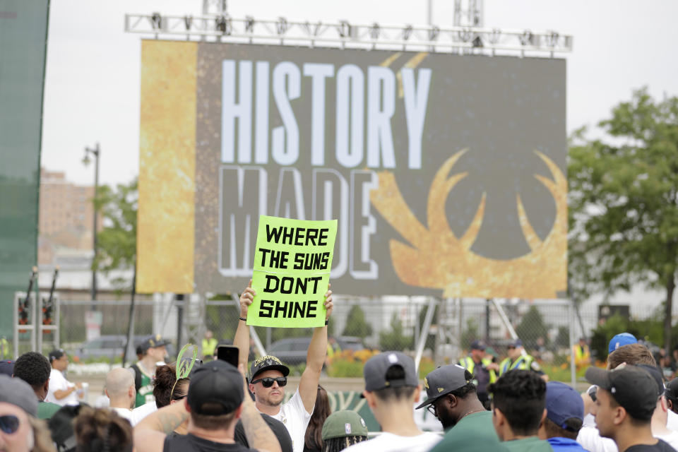 A fan holds up a sign before a parade celebrating the Milwaukee Bucks' NBA Championship basketball team Thursday, July 22, 2021, in Milwaukee. The Bucks defeated the Phoenix Suns 105-98 in Game 6 on Tuesday. (AP Photo/Aaron Gash)