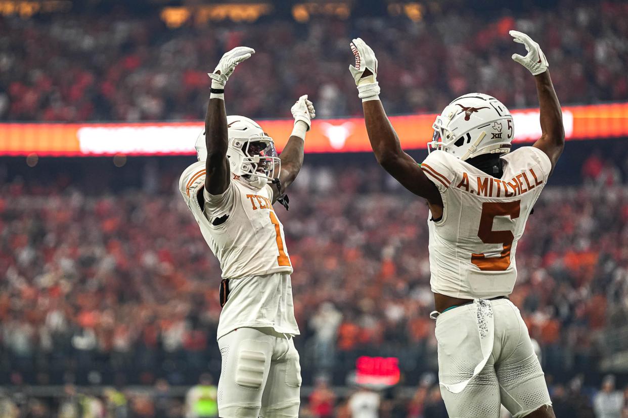 Texas wide receivers Xavier Worthy, left, and Adonai Mitchell celebrate Mitchell's touchdown catch during the Big 12 championship game win over Oklahoma State. The Longhorns, who have qualified for the College Football Playoff, hope to add nearly two dozen 2024 recruits on Wednesday's early signing day.