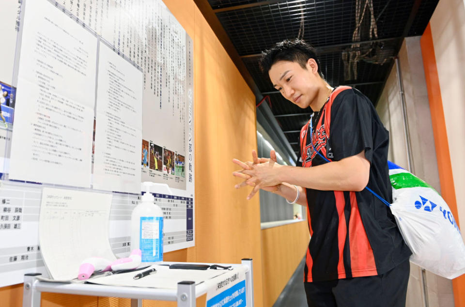 Japan's badminton player Kento Momota disinfects his hands prior to a training session in Tokyo on June 26, 2020. He has vowed to bring home Gold at the postponed Tokyo Games.<span class="copyright">Yohei Nishimura / POOL / AFP via Getty Images</span>