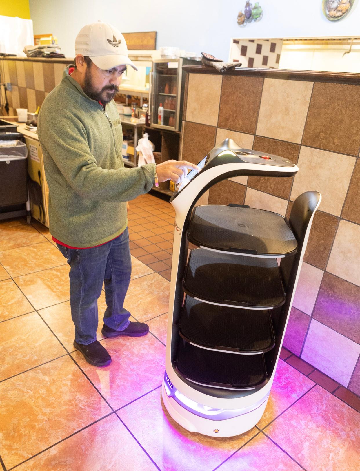 Don Tequila restaurant owner Feliciano Ramirez programs a food delivery into the BellaBot at his Canton location.