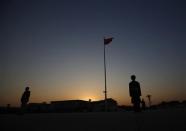 A paramilitary policeman stands guard next to the Chinese national flag on Tiananmen square as the sun sets behind the Great Hall of the People (background), where the closing ceremony of the Chinese Communist Party plenum is going to be held on Tuesday, in Beijing, November 11, 2013. REUTERS/Kim Kyung-Hoon