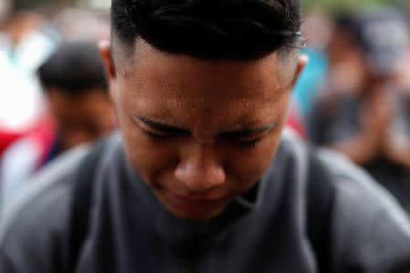 A man, part of a caravan of thousands of migrants from Central America en route to the U.S., prays before trying to cross the border into Mexico and carry on his journey, in Tecun Uman, Guatemala, October 28, 2018. REUTERS/Carlos Garcia Rawlins