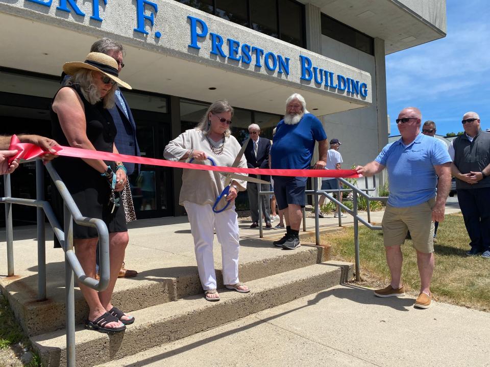 Martha Preston cuts the ribbon for the unveiling of her father Robert Preston's tribute at town hall, now called the Robert F. Preston Building.