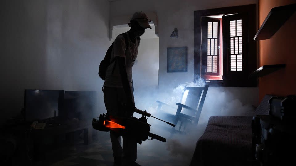 A health worker fumigates an apartment in Cuba as health authorities launch small-scale fumigation efforts in a bid to fight the spread of the oropouche virus. - Norlys Perez/Reuters