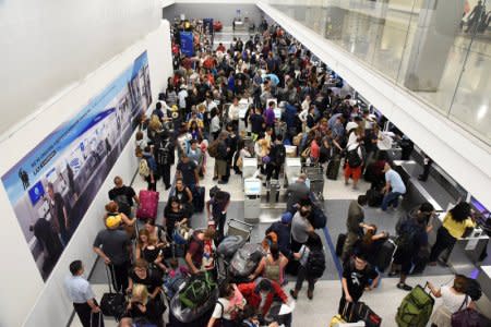 Delayed passengers inside Terminal 7 at Los Angeles International Airport line up to go through TSA security check following a false alarm event in Los Angeles, California U.S August 28, 2016.  REUTERS/Bob Riha Jr