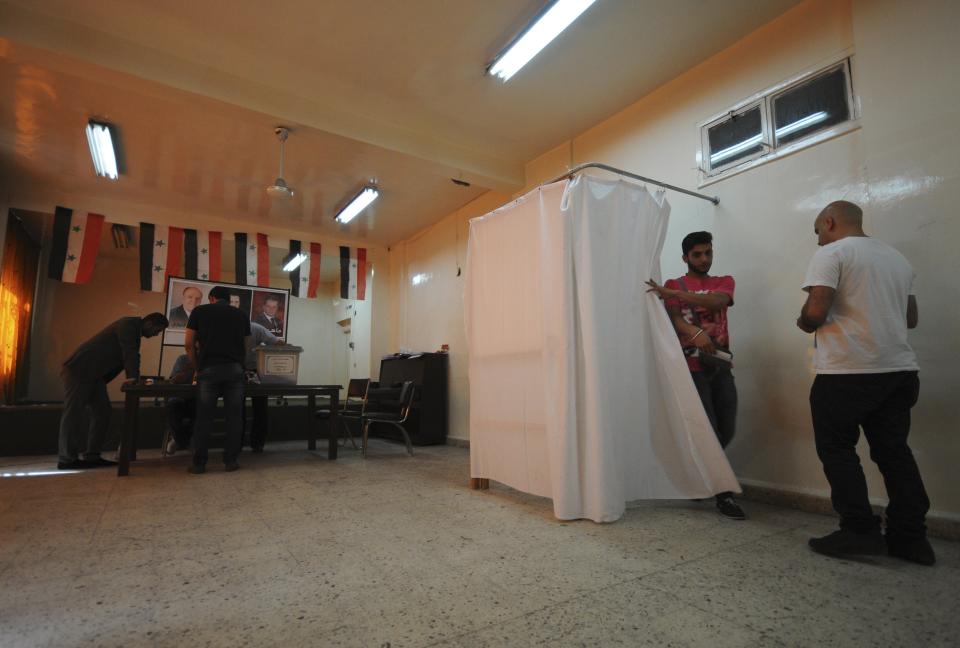 People cast their vote at a polling station in Damascus June 3, 2014. Syrians voted on Tuesday in an election expected to deliver an overwhelming victory to President Bashar al-Assad in the midst of a civil war that has fractured the country and killed more than 160,000 people. (REUTERS/ Omar Sanadiki)