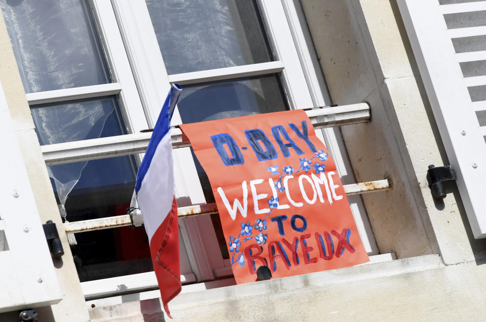 A placard is seen outside a window in front of the Cathedral of Bayeux, Normandy, Thursday June 6, 2019, as part of D-Day commemorations marking the 75th anniversary of the World War II Allied landings in Normandy. (Bertrand Guay/ POOL via AP)