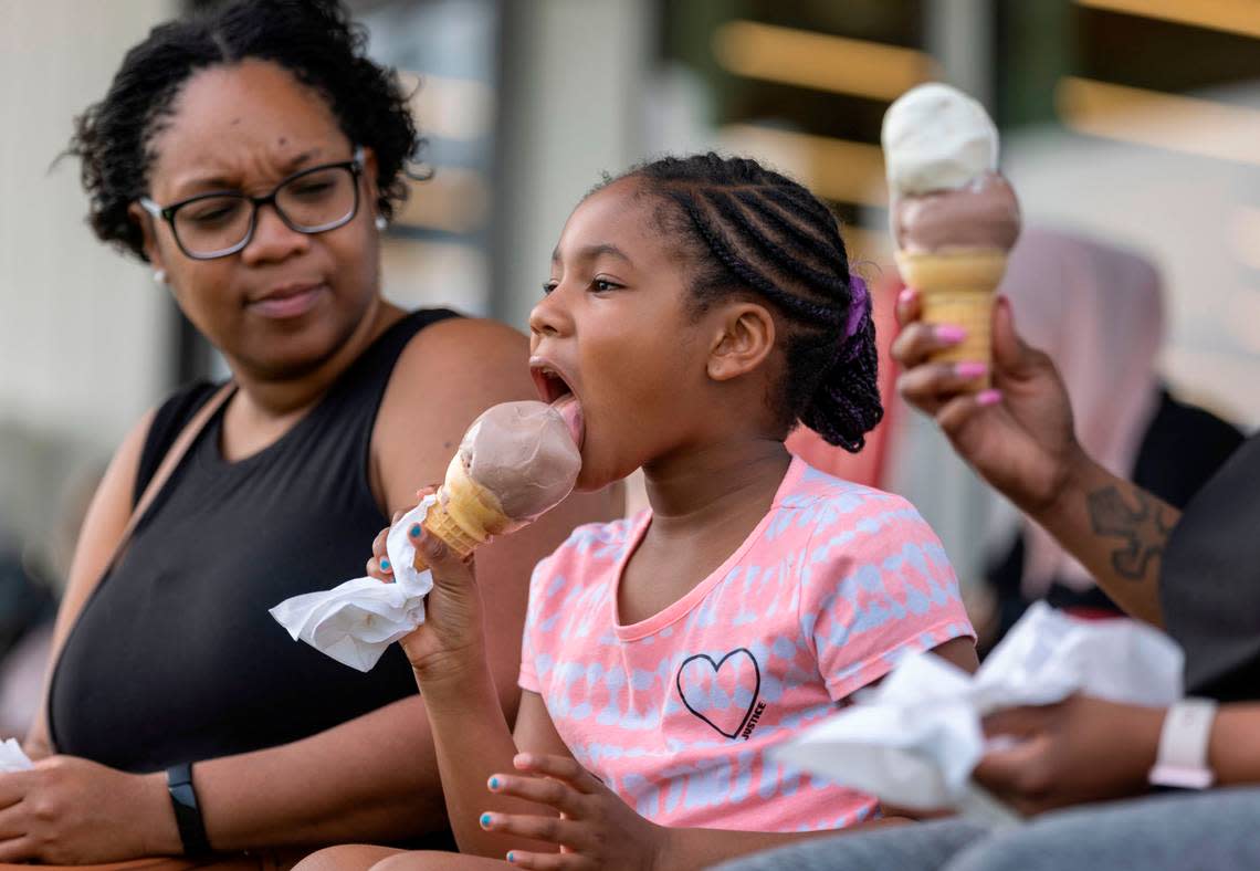 Seven-year-old Madison Bryant of Raleigh enjoys a cone of ice cream from the Howling Cow Creamery at the N.C. State Dairy Education Center with Shay Wiley on Tuesday July 5, 2022 in Raleigh, N.C.
