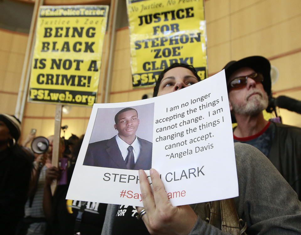 FILE - In this March 22, 2018, file photo, Anita Ross holds a photo of 22-year-old Stephon Clark, who was fatally shot by Sacramento police, as she and other protesters block the entrance to Sacramento City Hall in Sacramento, Calif. The shooting death of Clark helped spur the passage of two laws to take effect in 2020 giving California one of the nation's most comprehensive approaches to deterring shootings by police. One changes the legal standard for when police can use deadly force, while the companion law increased officers' training on how to handle confrontations. (AP Photo/Rich Pedroncelli, File)