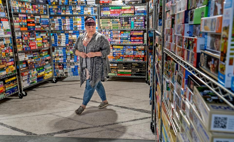 Kyle Walczak looks at the huge collection of jigsaw puzzles Friday, May 3, 2024 in her Carmel home. Her husband, John Walczak, recently achieved a Guinness World Record for the largest collection of jigsaw puzzles.