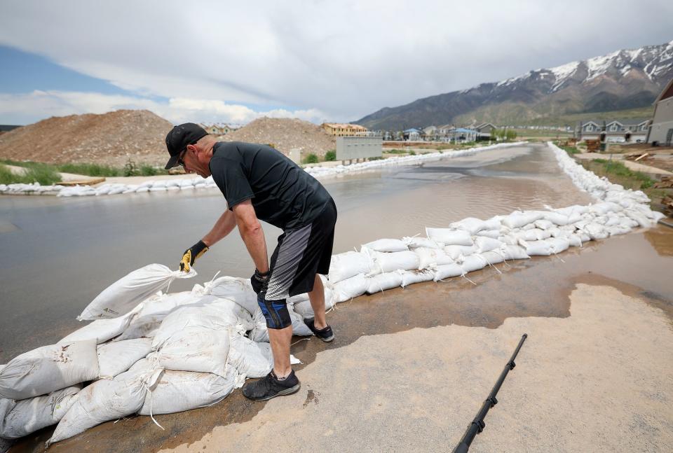 Santaquin Fire Capt. Corey Houskeeper sets up sandbags to contain flooding in Santaquin on Wednesday, May 17, 2023. | Kristin Murphy, Deseret News