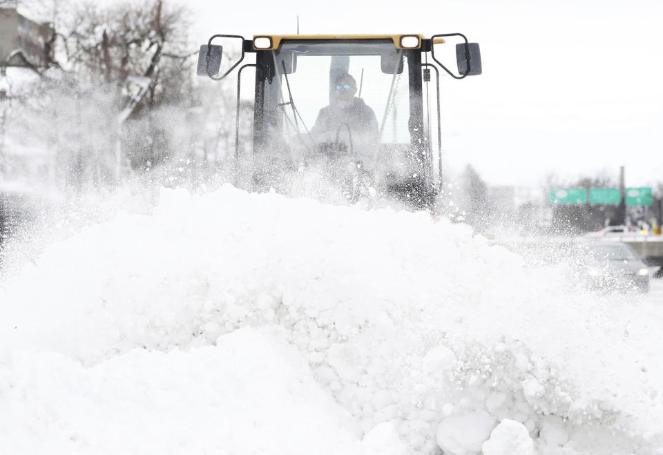 Legend Excavating worker Garrett LaCross plows snow off Interstate 33 in Buffalo, N.Y., on Tuesday, Dec. 27, 2022. Clean up is currently under way after a blizzard hit four Western New York counties. (Joseph Cooke/The Buffalo News via AP)