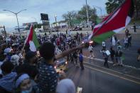 Activists supporting Palestine block traffic on Interstate 278 Saturday, May 15, 2021, in New York. The rally supports Palestine in the ongoing conflict between Israel and Palestine on the day Israeli airstrikes leveled several buildings in the Gaza strip. (AP Photo/Kevin Hagen)