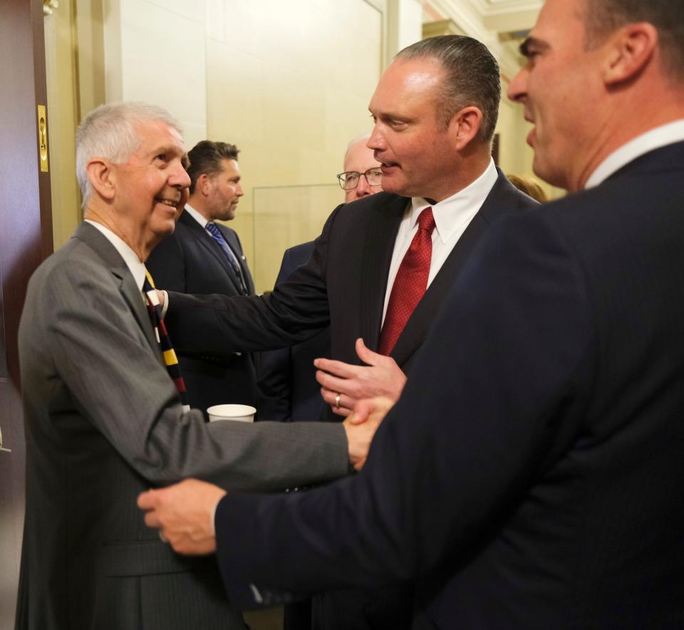 Retired Justice Steven W. Taylor shakes hands Monday with Gov. Kevin Stitt and House Speaker Charles McCall at a news conference to announce a historic education reform agreement.