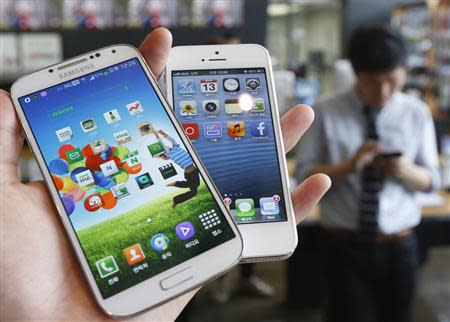 Samsung Electronics' Galaxy S4 (L) and Apple's iPhone 5 are seen in this file picture illustration taken in Seoul on May 13, 2013. REUTERS/Kim Hong-Ji/Files