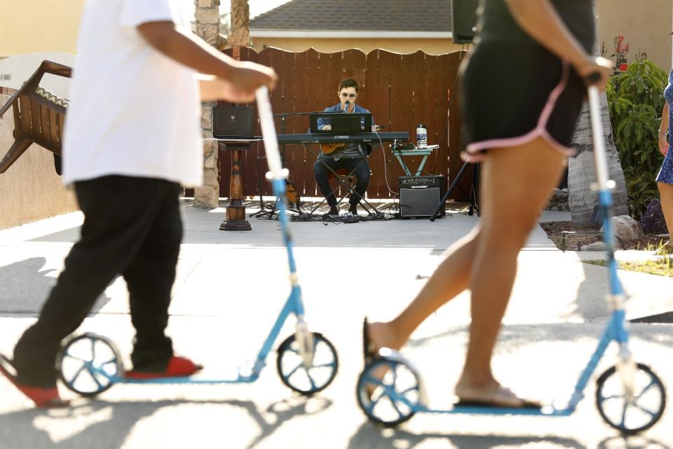 Andres O'Neil, 18, performs music in his driveway at home in Norwalk, California.