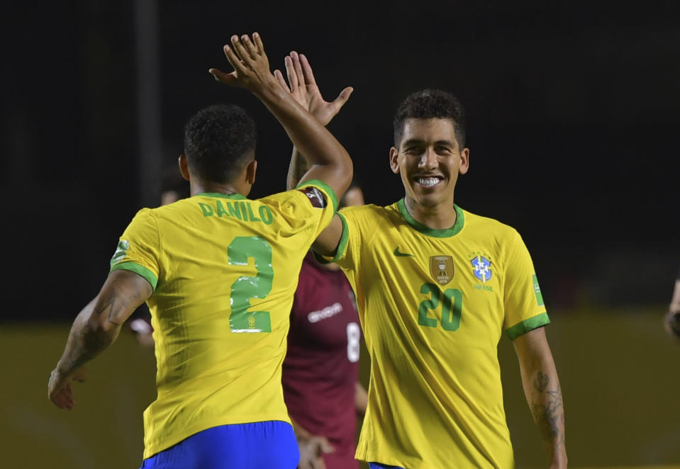 Brazil's Roberto Firmino, right, celebrates with teammate Brazil's Danilo after scoring his side's opening goal against Venezuela during a qualifying soccer match for the FIFA World Cup Qatar 2022 in Sao Paulo, Brazil, Friday, Nov.13, 2020. (Nelson Almeida/Pool via AP)