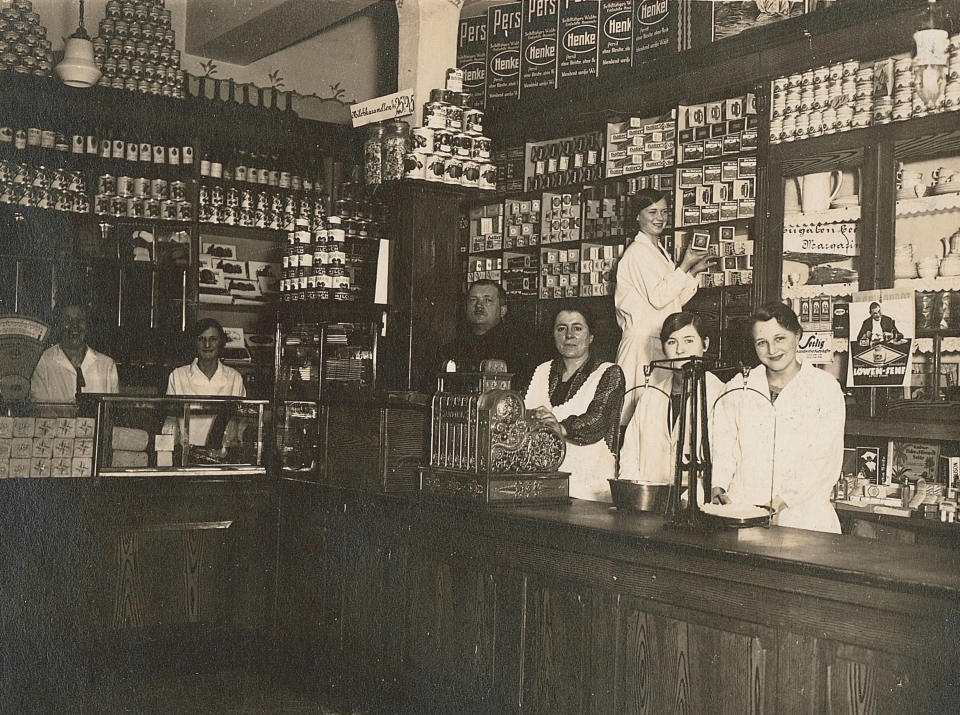 Aldi's history: Inside the family's store in 1930 with workers standing behind the wooden counter.