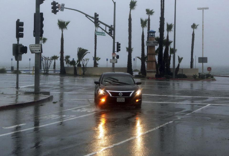 A car turns off Pacific Coast Highway during a downpour in the Pacific Palisades area of Los Angeles, Friday morning, Jan. 20, 2017. The second in a trio of storms has brought rain, heavy at times, over a wide area of California. The National Weather Service has issued a flood advisory for San Luis Obispo County as moderate to heavy rain falls on the Central Coast.(AP Photo/Reed Saxon)