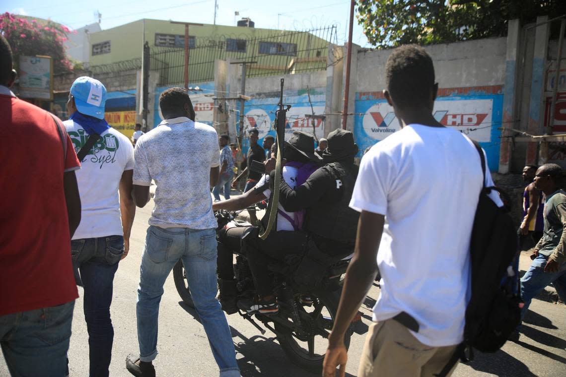 Armed and masked police officers move forward on a motorcycle during a protest to denounce bad police governance, in Port-au-Prince, Haiti, Thursday, Jan. 26, 2023.