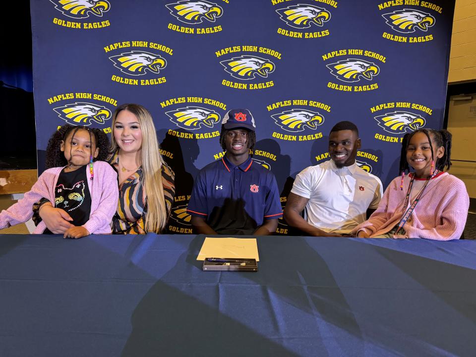 Naples defensive back Kensley Faustin is shown with his family during a signing ceremony on Thursday, Dec. 13, 2023 at Naples High School. Faustin committed to play at Auburn University next season.