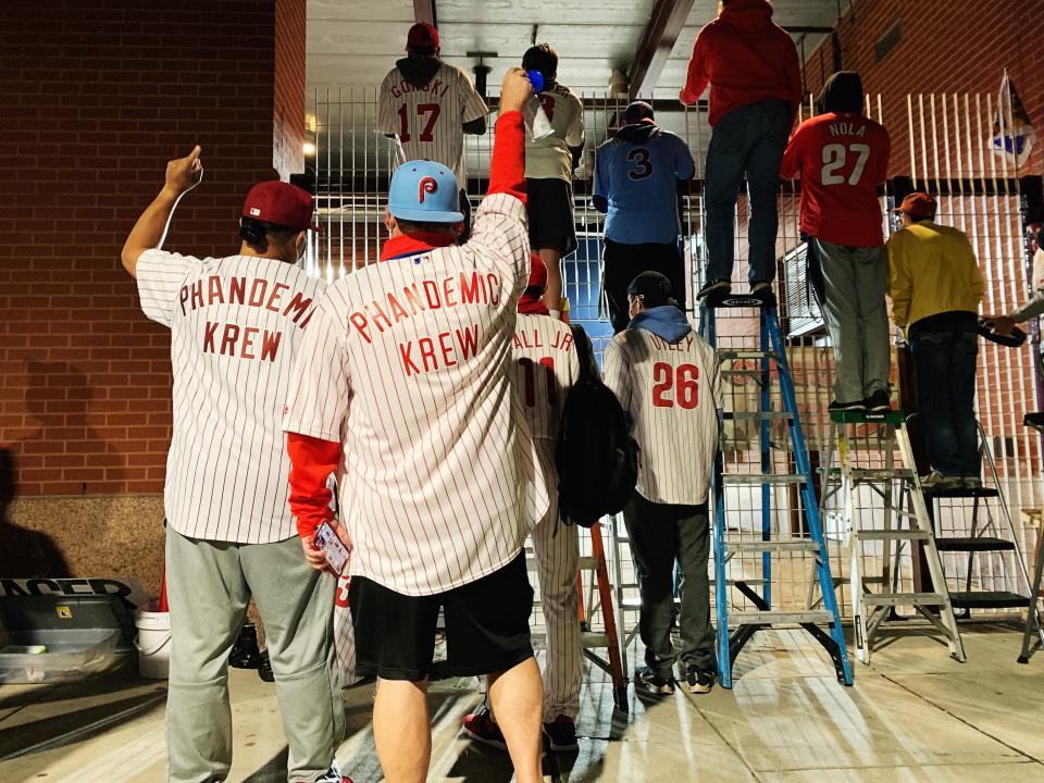 The Krew cheers from outside the gates in Philadelphia, taking turns on ladders to catch a glimpse of the field. (Photo by Hannah Keyser / Yahoo Sports)