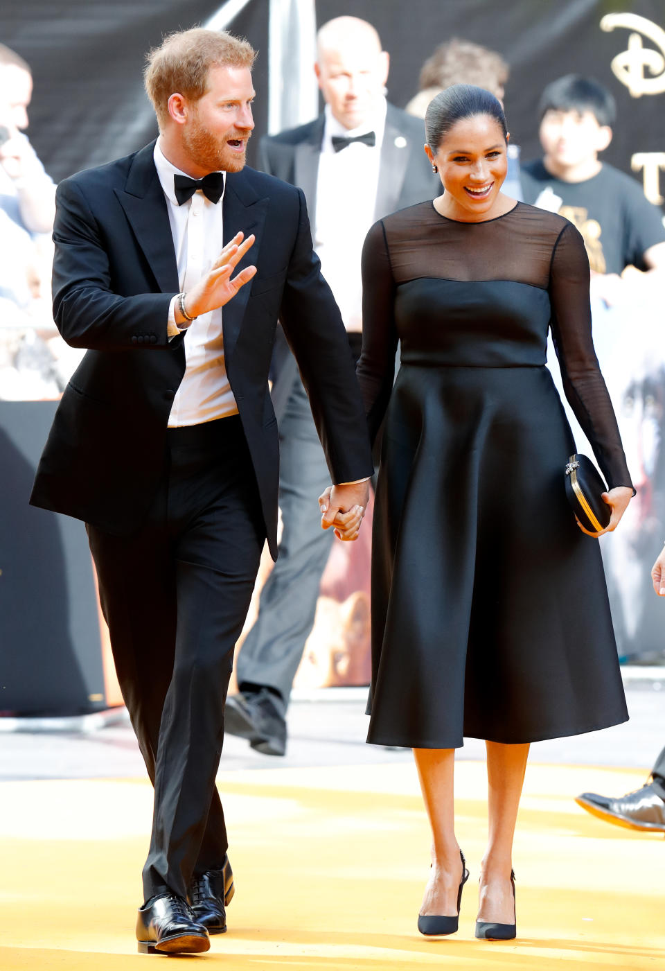 Meghan Markle and Prince Harry holding hands at the Lion King premiere