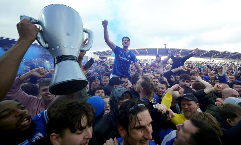 <span>Chesterfield’s players and fans rejoice on the pitch after promotion is sealed amid a dominant season.</span><span>Photograph: Martin Rickett/PA</span>