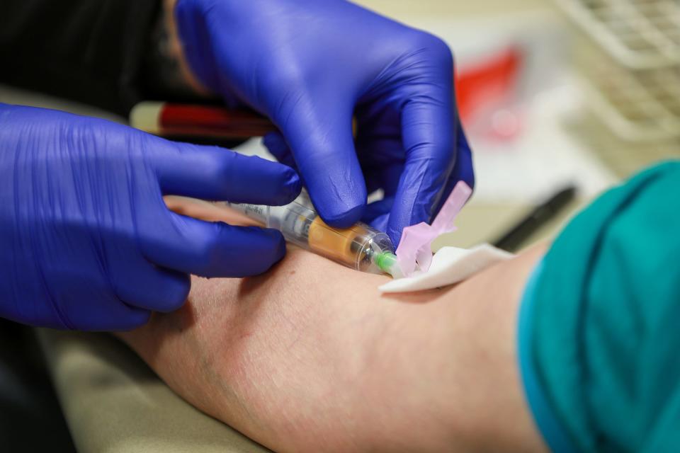 A medical assistant draws blood at the Dr. Gary Burnstein Community Health Clinic in Pontiac on Oct. 9, 2021.