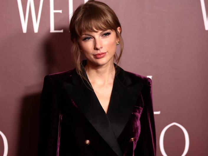 Taylor Swift smiles softly in a purple suit at the &quot;All Too Well&quot; short film premiere.