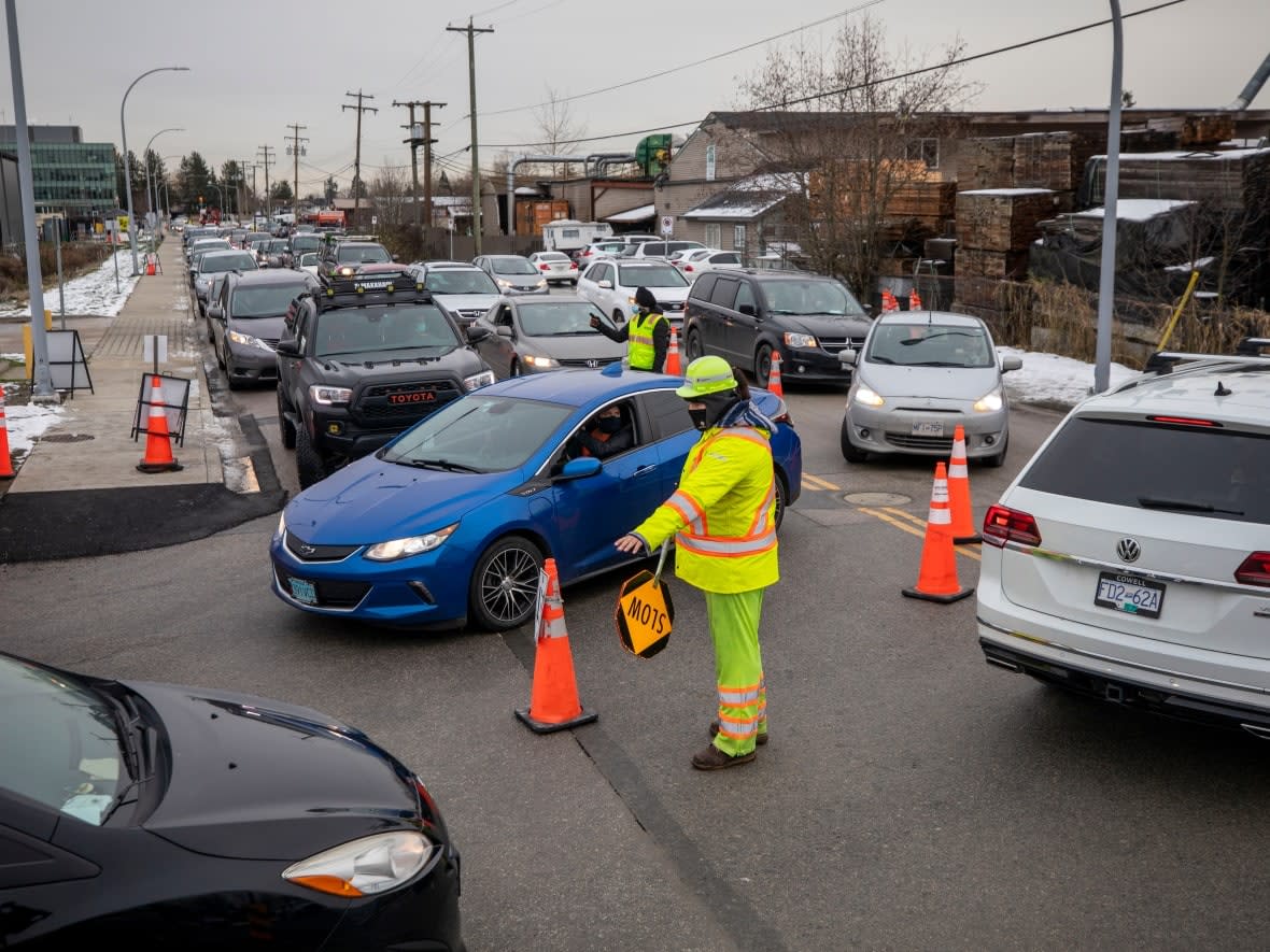 Cars are pictured lined up at a Fraser Health COVID-19 testing clinic in Surrey, B.C., on Tuesday.  (Ben Nelms/CBC - image credit)