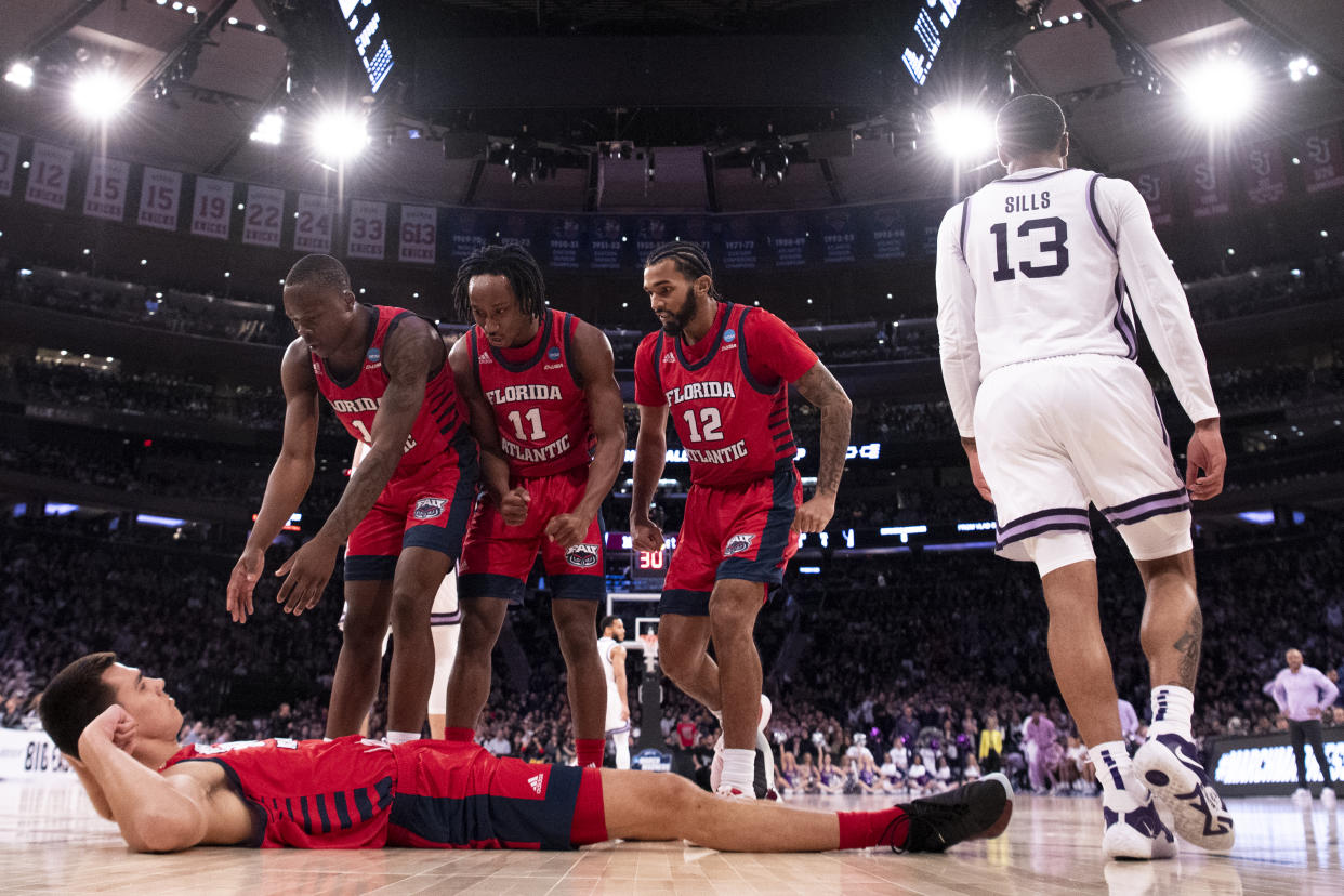 NEW YORK, NEW YORK - MARCH 25: Vladislav Goldin #50 of the Florida Atlantic Owls is helped up by teammates after drawing an offensive foul during the first half of the game against the Kansas State Wildcats during the Elite Eight round of the 2023 NCAA Men's Basketball Tournament held at Madison Square Garden on March 25, 2023 in New York City. (Photo by Ben Solomon/NCAA Photos via Getty Images)