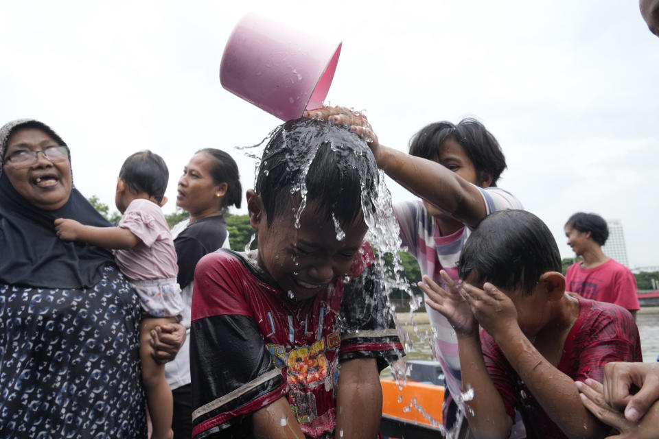 People bathe in the Cisadane River, ahead of the holy fasting month of Ramadan in Tangerang, Indonesia, Sunday, March 10, 2024. Muslims followed local tradition to wash in the river to symbolically cleanse their soul prior to entering the holiest month in Islamic calendar. (AP Photo/Achmad Ibrahim)