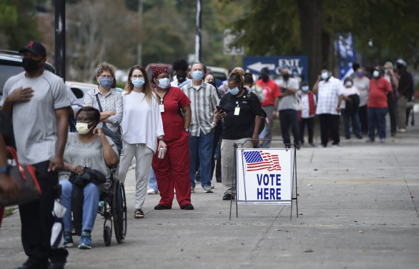 Monday was the first day for advance voting in Georgia and people showed up by the hundreds to cast their ballot early at the Bell Auditorium in Augusta, Ga., Monday, Oct. 12, 2020 (Michael Holahan/The Augusta Chronicle via AP)