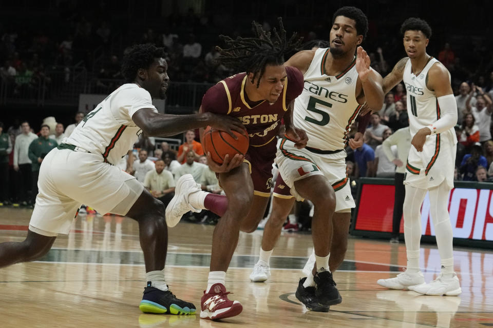 Miami guard Bensley Joseph (4) and guard Harlond Beverly (5) defend Boston College guard DeMarr Langford Jr. (5) during the second half of an NCAA college basketball game, Wednesday, Jan. 11, 2023, in Coral Gables, Fla. (AP Photo/Marta Lavandier)