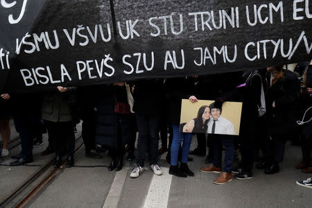 People carry the picture of Slovak investigative reporter Jan Kuciak and his fiancee Martina Kusnirova during a march in reaction to their murder, in Bratislava, Slovakia March 23, 2018. REUTERS/David W. Cerny. NO RESALES. NO ARCHIVES