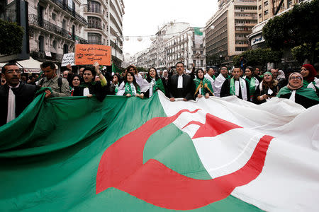 Lawyers carry a national flag as they march during a protest to demand the immediate resignation of President Abdelaziz Bouteflika, in Algiers, Algeria March 23, 2019. REUTERS/Ramzi Boudina